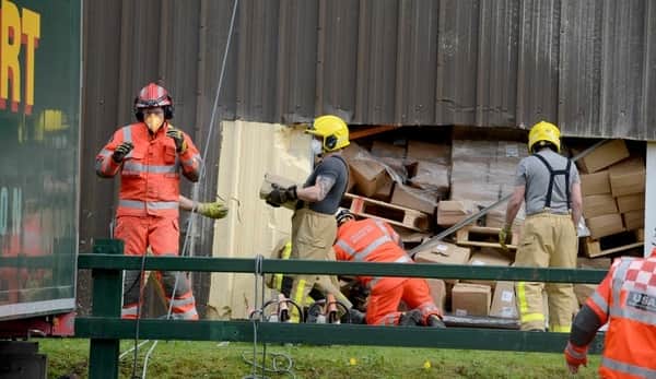 Fire crews clear a path to the trapped man through a hole cut in the wall