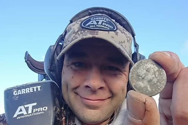 Chris Langston with a coin he found earlier this year