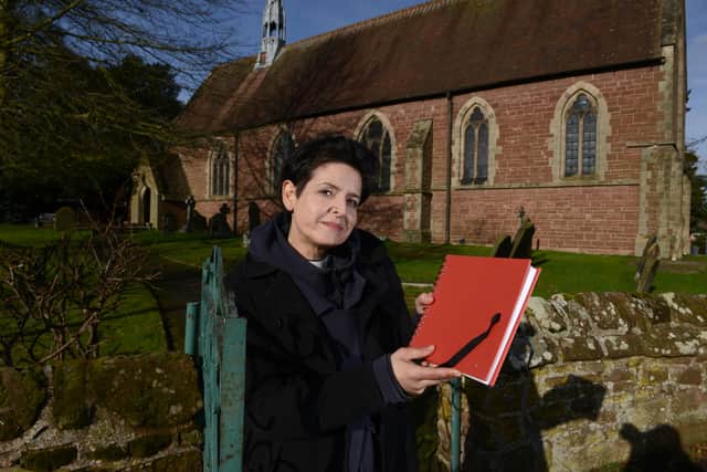 Vicar of St Andrew's Church, Zoe Heming, with a book where people can write down their thoughts and feelings over the tragedy