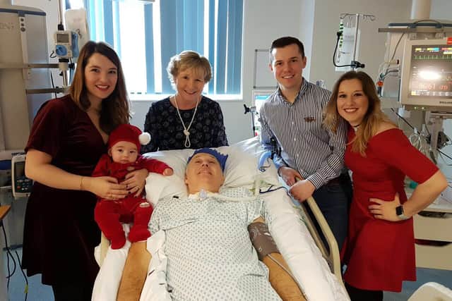 Sarah, left, holding Elliott, Celia, Andrew and Louise around Alan's bed on Christmas Day last year. The family are hopeful he could be home by this Christmas.