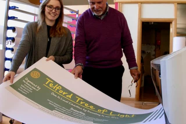 Rhi Moore and Peter Llewellyn of Telford Reprographics with a Telford Tree of Light Poster as it emerges from the printer.