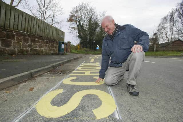 Councillor Colin Case takes a look at the new school road markings outside the old school house in Ryton XI Towns