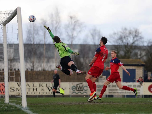 Zac Jones of Vauxhall Motors watches this shot from Shaun Whalley of AFC Telford United sail over his bar