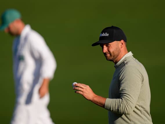 Wyndham Clark waves after his putt on the second hole