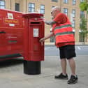 Postman at a Royal Mail post box