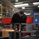 A UK factory worker at work welding steel.