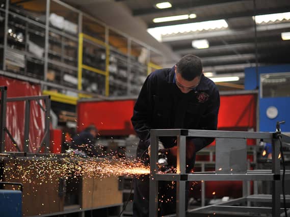 A UK factory worker at work welding steel.