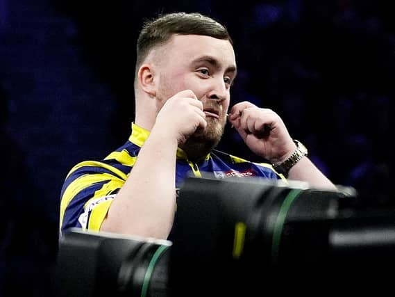 Luke Littler gestures on stage