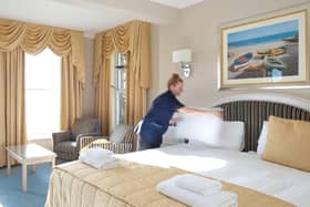 A housemaid making up a bed in a hotel
