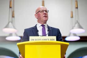 John Swinney speaking from an SNP lectern