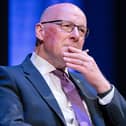 John Swinney seated, with one hand resting on his chin