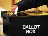 A voter places a ballot paper in the ballot box at the polling station