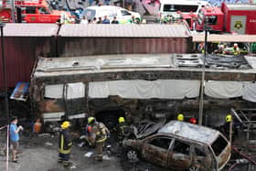 Rescuers work on a charred shell of a bus after a terrible tragedy