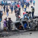 People strip parts from a burned-out vehicle during a public transport strike over fuel prices in Nairobi, Kenya