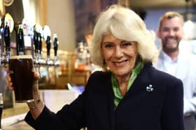 The Queen holds a pint of Guinness in a pub in the village of Hillsborough