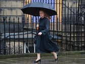 Shirley-Anne Somerville sheltering under an umbrella while walking along a street