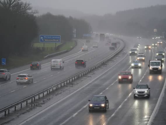 Vehicles drive through the rain on the M40 motorway near Warwick