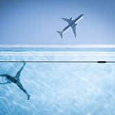 A person swimming in the sky pool in Nine Elms, south London, while a plane rises in the sky