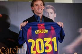 Anthony Gordon holds up a Barcelona shirt after signing for the club