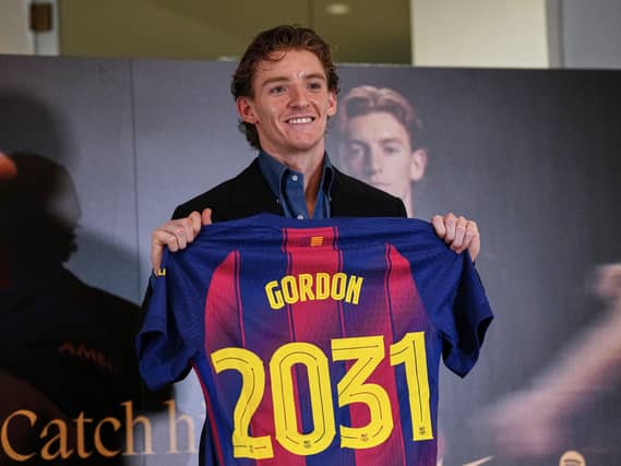 Anthony Gordon holds up a Barcelona shirt after signing for the club