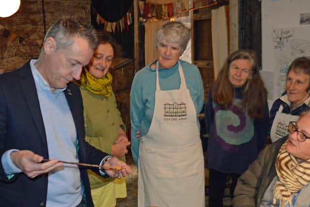 Alexander Clement from Halls | The Auction House examining a bayonet watched by Open Arms Kington CIC supporters at a previous charity antiques valuation day in Kington.
