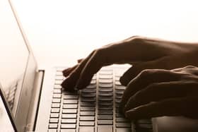 Hands typing on a laptop