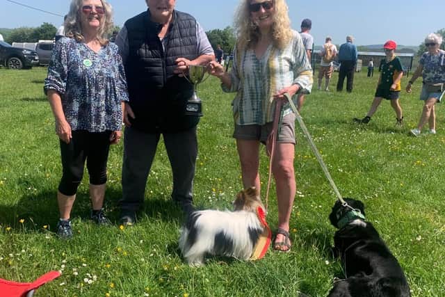 Lynne Harling receiving the Championship cup in the dog show from 'Brian The Bank' with Dog Show co-organiserTonia Greene.