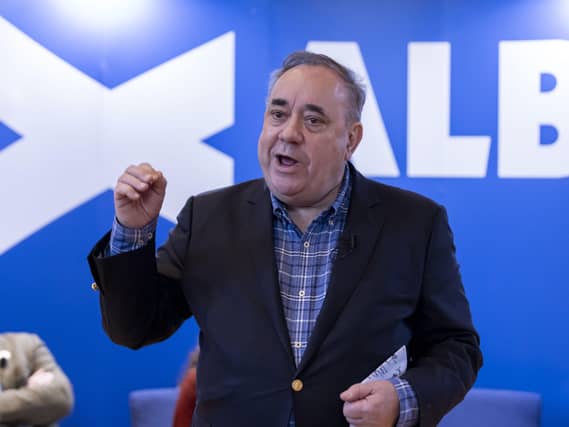 Alex Salmond speaking in front of Alba Party signage