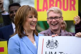 Chancellor Rachel Reeves holding up a sign