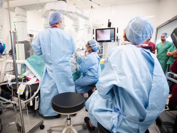 Surgeons look at a screen displaying an AI overlay of patient anatomy, including nerves and connective tissue during bowel resection surgery