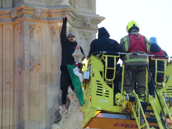 Emergency services talking to Daniel Day after he climbed up Elizabeth Tower at the Palace of Westminster