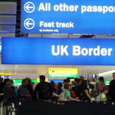 People in an airport under a UK Border sign