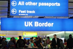 People in an airport under a UK Border sign