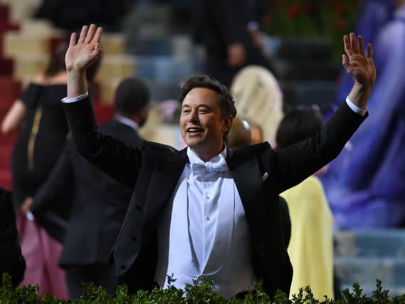Elon Musk raises his arms