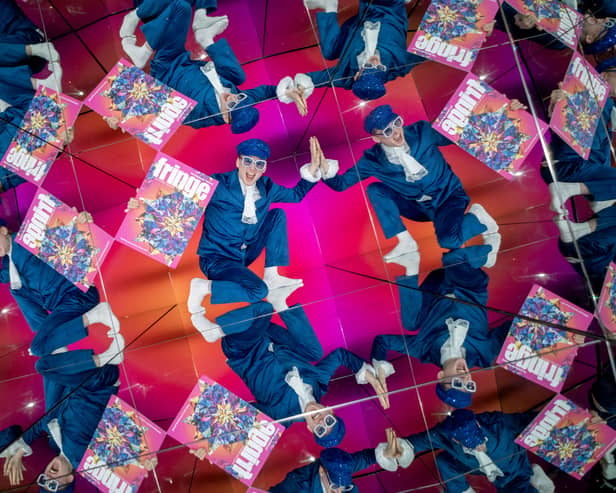 A performer holding a Fringe programme, reflected several times in giant kaleidoscope