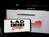 A mobile phone with the logo of British media company Ladbible Group Limited on screen in front of web page.