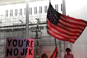 People wait for President Donald Trump’s name to be removed