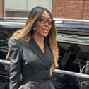 Naomi Campbell walking outside next to a black car