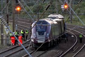 Damaged train on rail tracks with police officers and rail workers