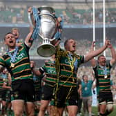 Northampton Saints players celebrate with the trophy on the pitch