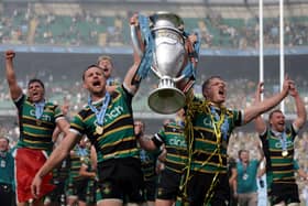 Northampton Saints players celebrate with the trophy on the pitch