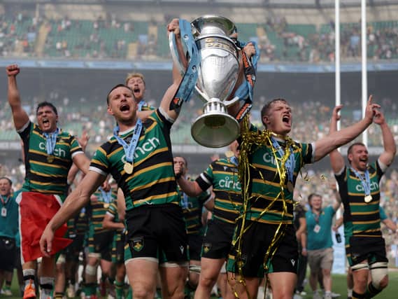 Northampton Saints players celebrate with the trophy on the pitch