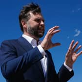JD Vance gesturing with his hands while speaking, under a blue sky
