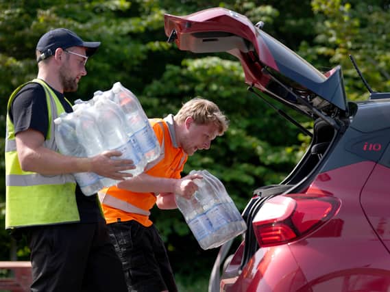 South east water staff hand out bottled water at a water collection point near Herne Bay in Kent