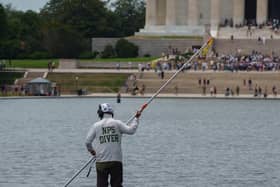 A National Park Service employee works to clean the Lincoln Memorial Reflecting Pool