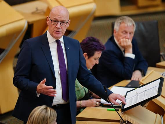 John Swinney standing while speaking in Holyrood