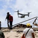 A US aircraft flies over an area struck by earthquakes in La Guaira, Venezuela