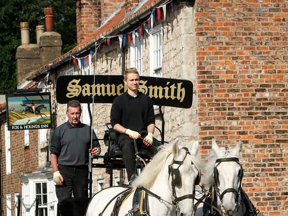 Kegs of beer being delivered to local pubs by a horse drawn cart from the Samuel Smith Old Brewery in Tadcaster