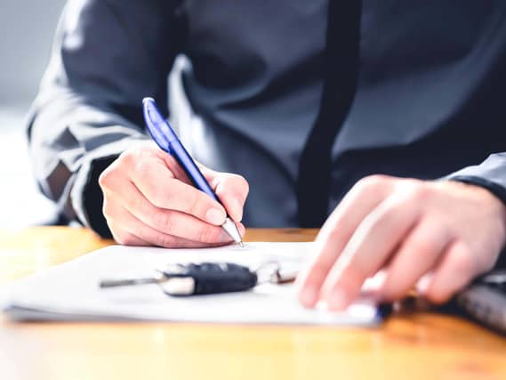 Man signing loan for car