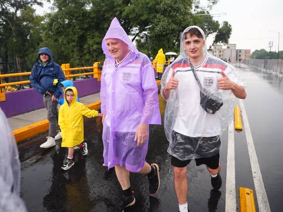 Fans arrive in the rain for the match against Mexico